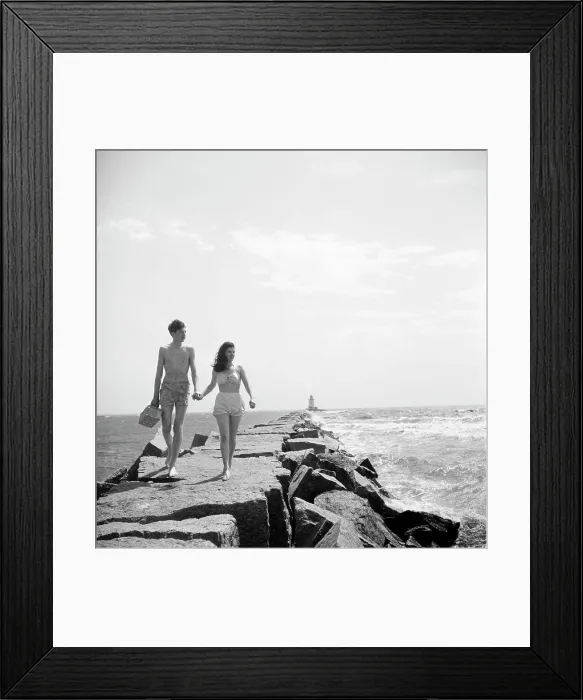 Framed Print : Young couple walking along groyne Framed Print : Young couple walking along groyne
