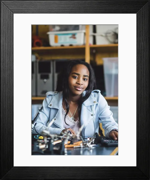 Framed Print : Portrait of smiling female high school student sitting with science project at desk in classroom