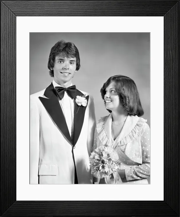 Framed Print : 1970s TEEN COUPLE DRESSED UP FOR PROM DANCE FORMAL ATTIRE GIRL HOLDING BOUQUET LOOKING UP AT TALL BOY