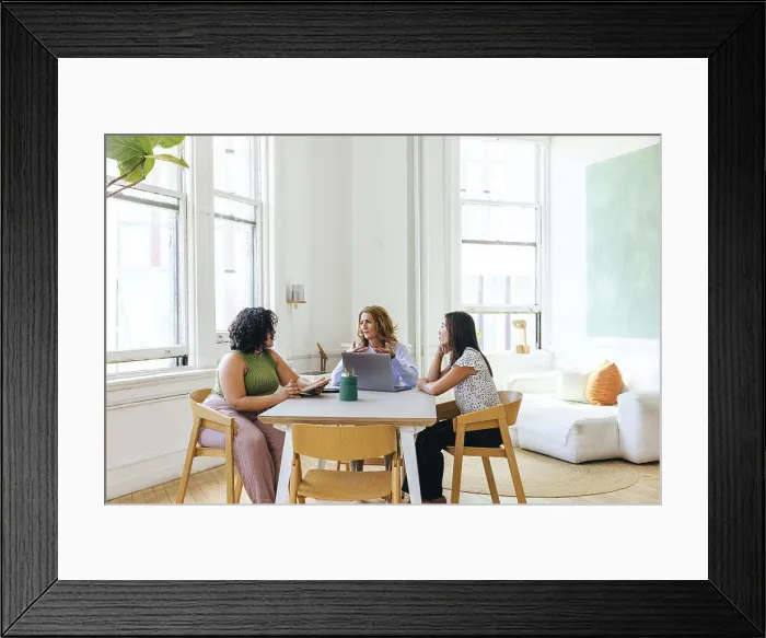 Framed Print : Multiracial businesswomen discussing business strategy at table Framed Print : Multiracial businesswomen discussing business strategy at table