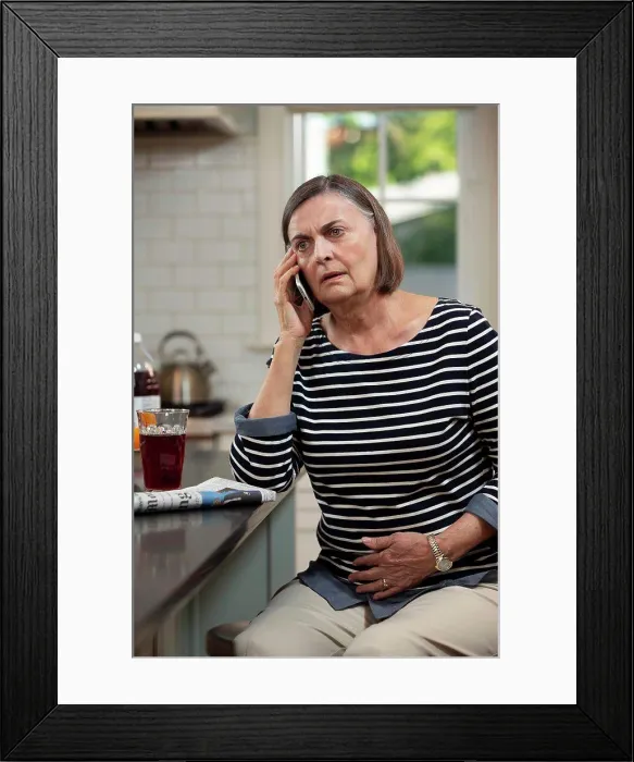 Framed Print : Senior Caucasian woman in her kitchen describing her abdominal pain to doctor on the phone Framed Print : Senior Caucasian woman in her kitchen describing her abdominal pain to doctor on the phone
