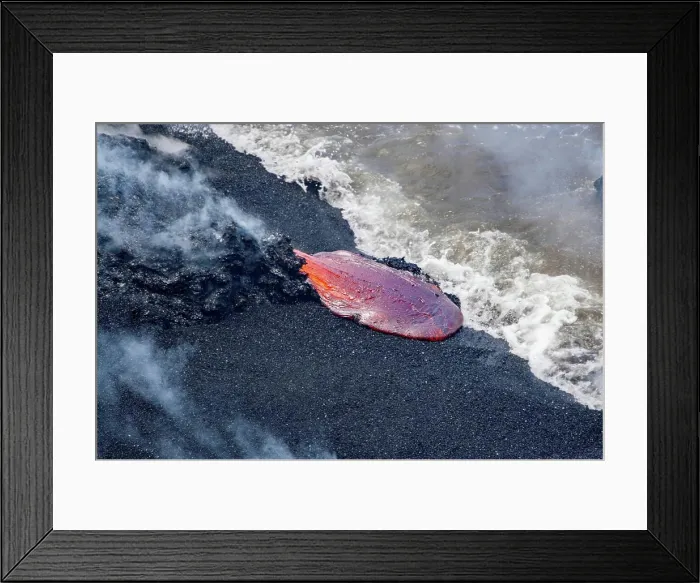 Framed Print : The Pahoehoe lava flowing from Kilauea has reached a black sand beach and the Pacific ocean near Kalapana