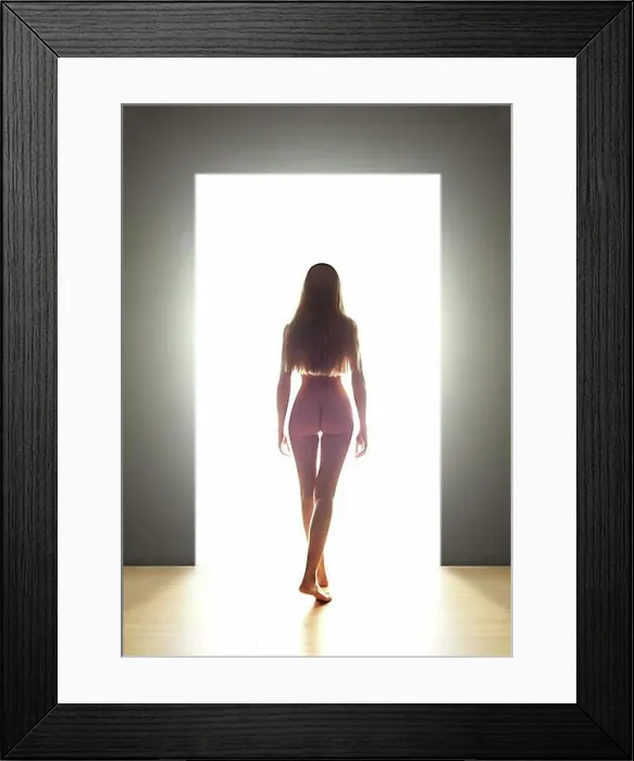 Framed Print : Naked young woman, back view, going through a door into the light Framed Print : Naked young woman, back view, going through a door into the light