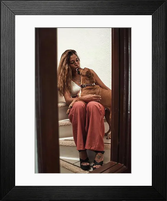 Framed Print : Beautiful young latina hugging her dog showing her affection on the stairs of her house. Love for animals Framed Print : Beautiful young latina hugging her dog showing her affection on the stairs of her house. Love for animals