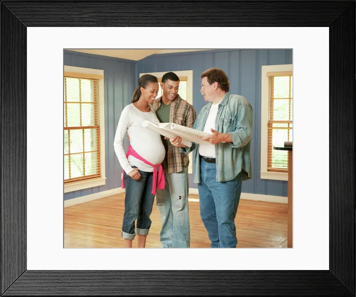 Framed Print : Architect reviewing blueprints with couple