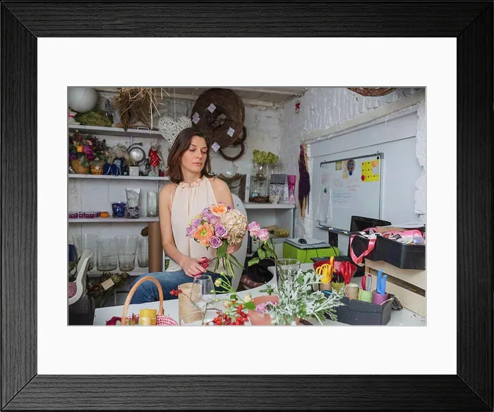 Framed Print : Female owner making flower bouquet at store