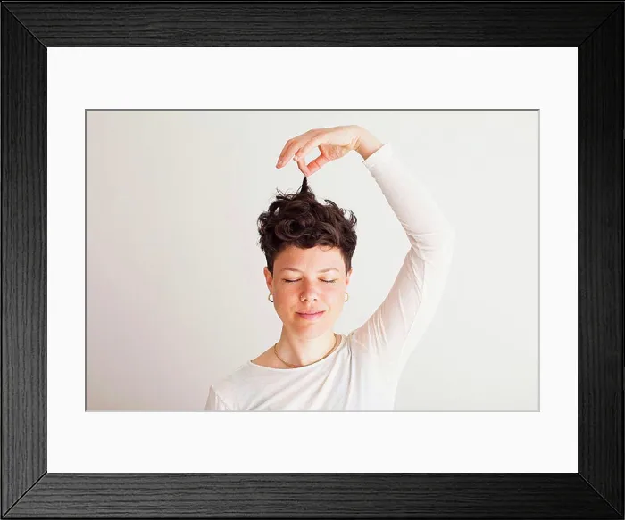 Framed Print : Close-up of happy mid adult woman holding her hair against white background Framed Print : Close-up of happy mid adult woman holding her hair against white background