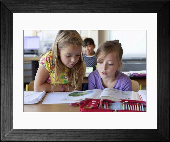 Framed Print : Girls reading book in classroom Framed Print : Girls reading book in classroom