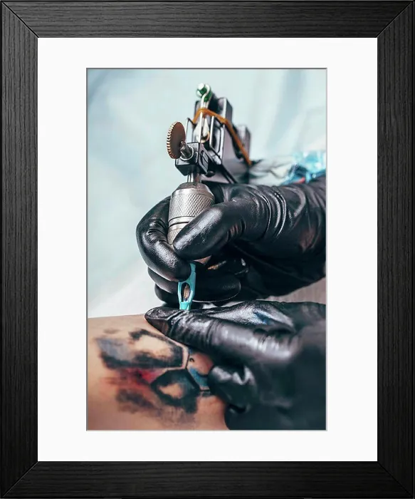 Framed Print : Artist tattooing design on human hand Framed Print : Artist tattooing design on human hand