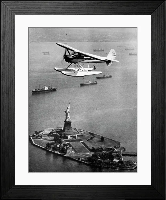 Framed Print : Statue Of Liberty In New York Harbour -- Aerial view shows seaplane flying overhead Framed Print : Statue Of Liberty In New York Harbour -- Aerial view shows seaplane flying overhead