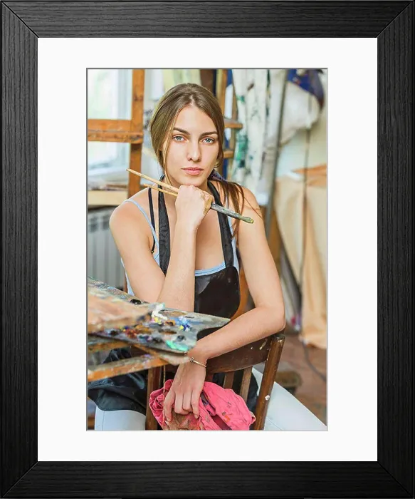 Framed Print : Portrait of beautiful female painter sitting on chair in studio Framed Print : Portrait of beautiful female painter sitting on chair in studio