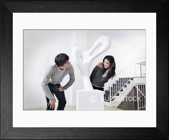 Framed Print : Germany, Cologne, Young couple standing in art gallery, smiling