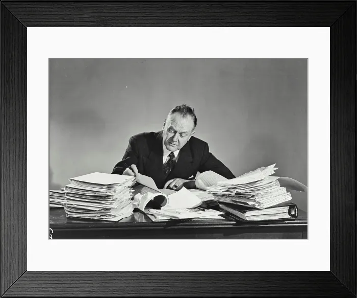 Framed Print : Vintage photograph. Older man in pinstripe suit sitting at desk full of papers Framed Print : Vintage photograph. Older man in pinstripe suit sitting at desk full of papers