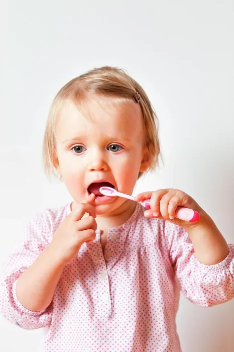 Framed Print : 18 month old baby girl brushing her teeth