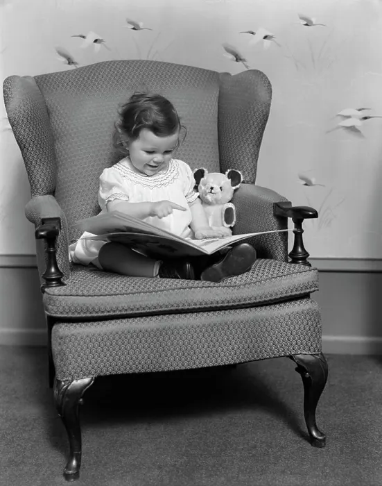 Framed Print : 1930S Little Girl Child In Large Chair With Bear Reading Book Framed Print : 1930S Little Girl Child In Large Chair With Bear Reading Book