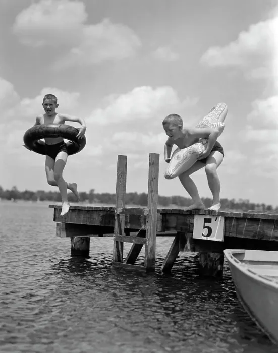 Framed Print : 1940S 1950S Two Boys Wearing Inflatable Inner Tubes About To Jump In Lake Off Pier Framed Print : 1940S 1950S Two Boys Wearing Inflatable Inner Tubes About To Jump In Lake Off Pier