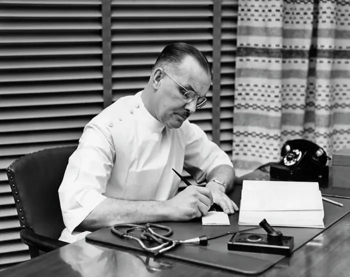 Framed Print : 1940S Doctor Sitting At Desk Writing Prescription Framed Print : 1940S Doctor Sitting At Desk Writing Prescription