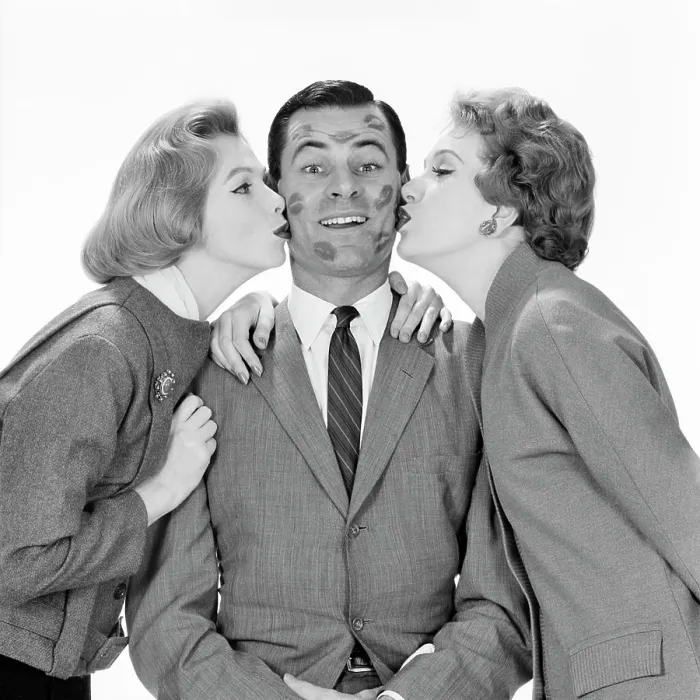 Framed Print : 1950s 1960s SMILING SINGLE MAN LOOKING AT CAMERA BEING KISSED BY TWO WOMEN
