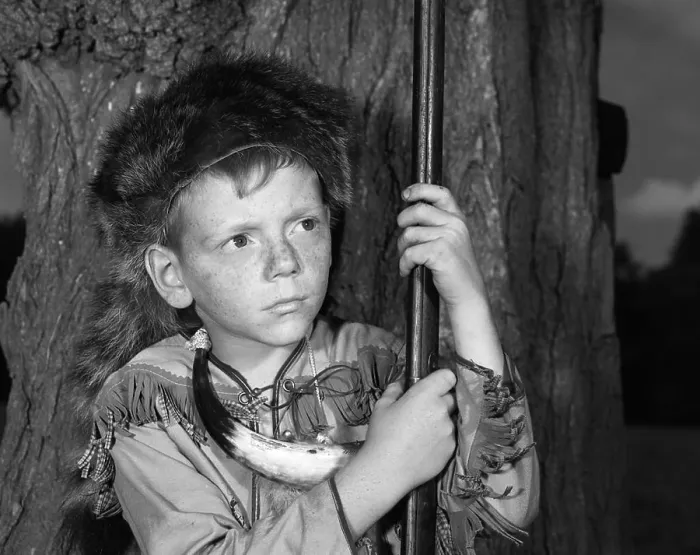 Framed Print : 1950s BOY WEARING RACCOON SKIN HAT FRINGED WESTERN STYLE JACKET WITH POWDER HORN AND ANTIQUE RIFLE Framed Print : 1950s BOY WEARING RACCOON SKIN HAT FRINGED WESTERN STYLE JACKET WITH POWDER HORN AND ANTIQUE RIFLE