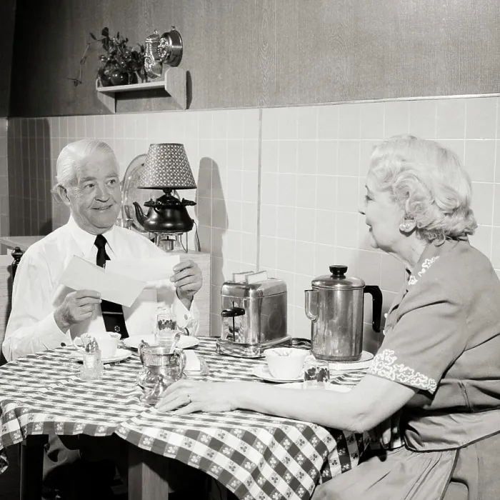 Framed Print : 1950s SENIOR COUPLE SITTING AT KITCHEN TABLE HAVING TOAST AND COFFEE MAN OPENING MORNING MAIL SMILING HOLDING CHECK