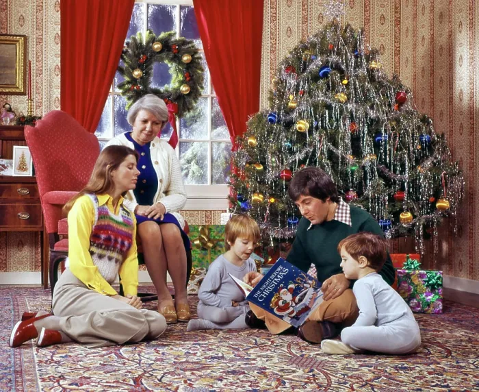 Framed Print : 1970s FAMILY READING CHRISTMAS BOOK MOTHER FATHER SONS GRANDMOTHER