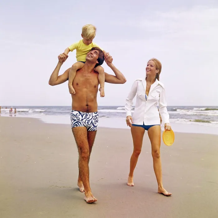Framed Print : 1970s YOUNG FAMILY WALKING DOWN BEACH TODDLER RIDING ON FATHERS SHOULDERS