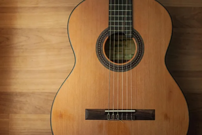 Framed Print : Acoustic guitar resting against a wooden background Framed Print : Acoustic guitar resting against a wooden background