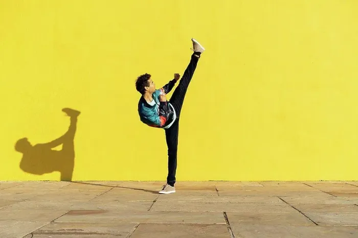 Framed Print : Acrobat doing movement training in front of a yellow wall Framed Print : Acrobat doing movement training in front of a yellow wall
