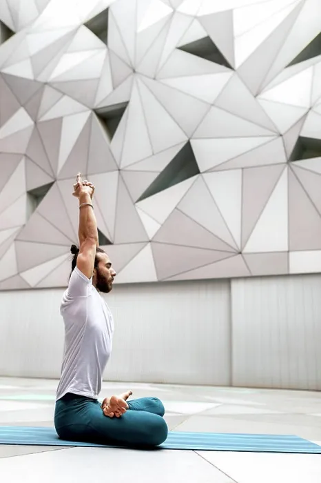 Framed Print : Adult bearded man in sportswear sitting crossed legged and meditating with closed eyes