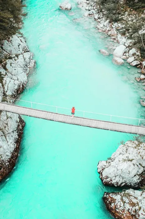 Framed Print : Aerial shot of young woman standing on bridge above whitewater river Framed Print : Aerial shot of young woman standing on bridge above whitewater river