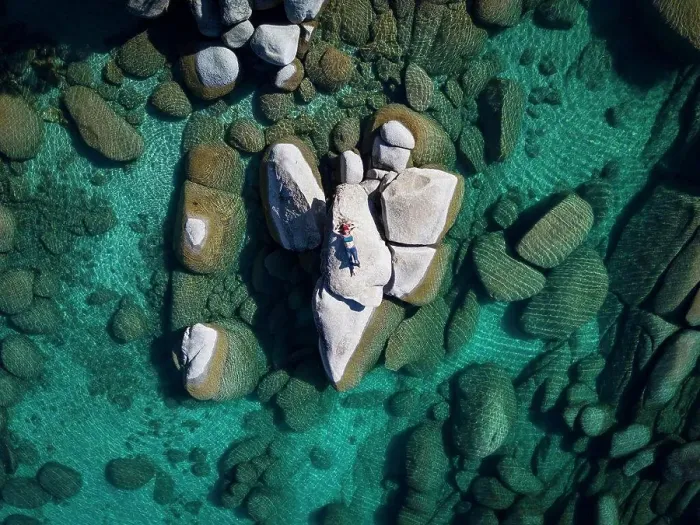 Framed Print : aerial view female laying on rock in lake tahoe