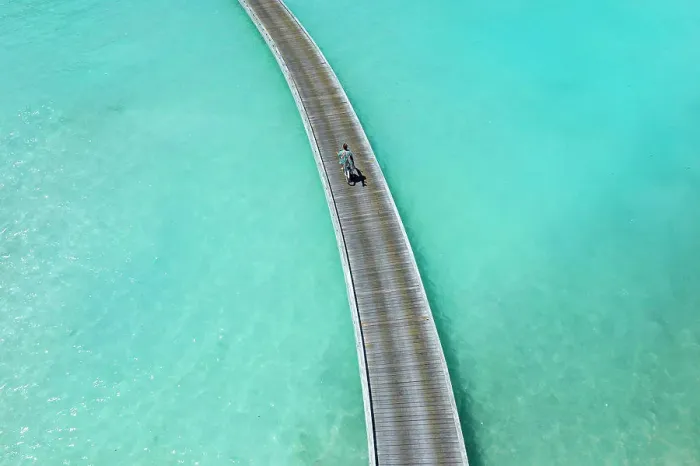 Framed Print : Aerial view of long man riding by bicycle on jetty in the sea Framed Print : Aerial view of long man riding by bicycle on jetty in the sea