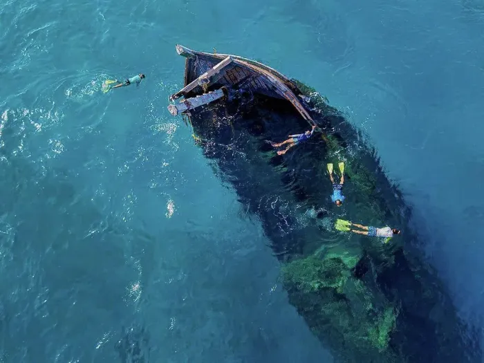Framed Print : Aerial view of four men snorkeling around sunken shipwreck Framed Print : Aerial view of four men snorkeling around sunken shipwreck