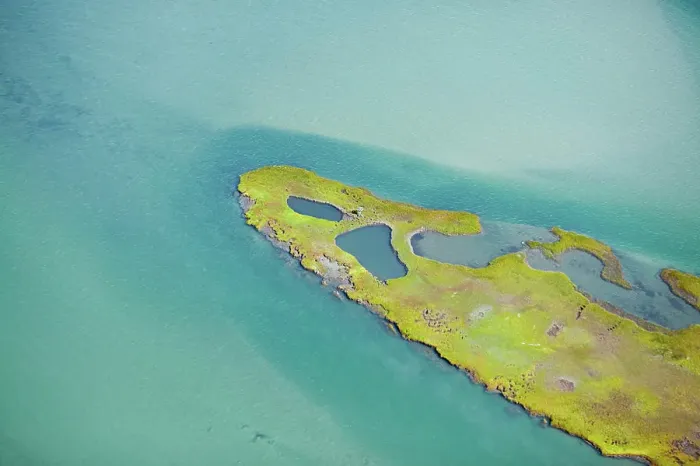 Framed Print : Aerial view of a serene turquoise waterbody with a lush green island Framed Print : Aerial view of a serene turquoise waterbody with a lush green island