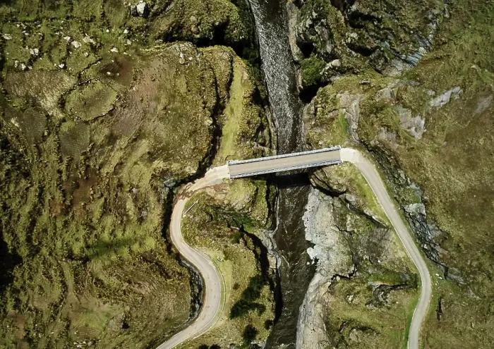 Framed Print : Aerial view of a solitary bridge over a mountain stream Framed Print : Aerial view of a solitary bridge over a mountain stream