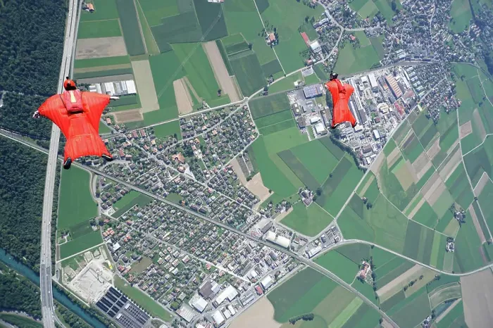 Framed Print : Aerial view of two wingsuit flyers in red suits flying above landscape