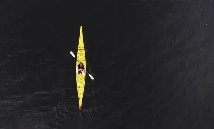 Framed Print : Aerial view of woman paddling yellow kayak on dark lake water Framed Print : Aerial view of woman paddling yellow kayak on dark lake water