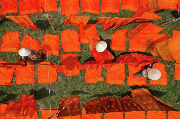 Framed Print : Aerial view of woman working in a public laundry drying red cloth in Araihazar, Dhaka, Bangladesh Framed Print : Aerial view of woman working in a public laundry drying red cloth in Araihazar, Dhaka, Bangladesh
