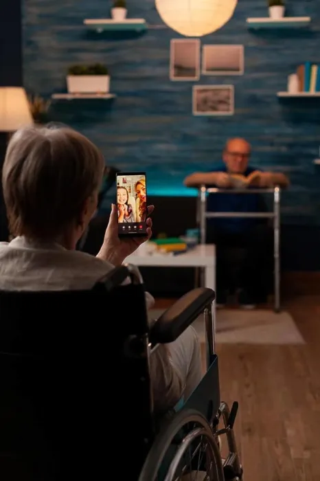 Framed Print : Aged disabled woman holding smartphone for video call Framed Print : Aged disabled woman holding smartphone for video call