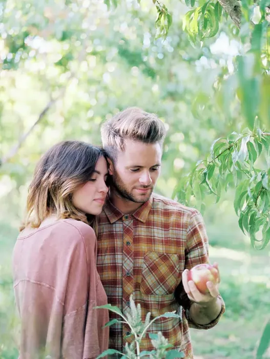 Framed Print : An apple orchard in Utah. A couple standing by an apple tree, holding an apple Framed Print : An apple orchard in Utah. A couple standing by an apple tree, holding an apple