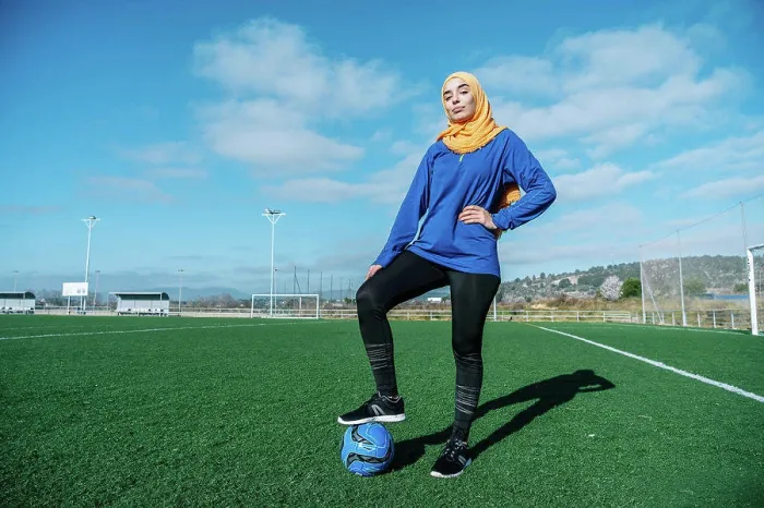 Framed Print : Arab female football player with ball on field