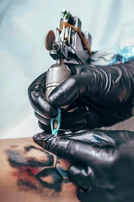 Framed Print : Artist tattooing design on human hand Framed Print : Artist tattooing design on human hand
