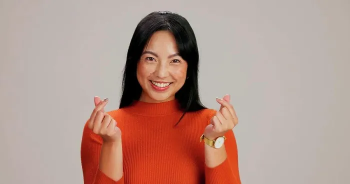 Framed Print : Asian girl, finger heart and happy in studio portrait
