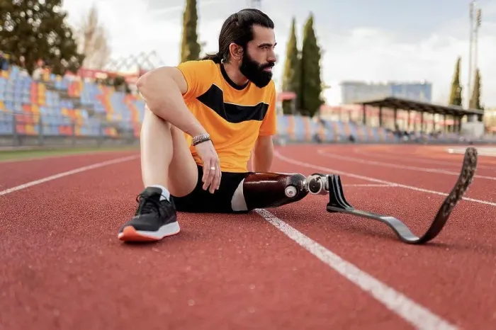 Framed Print : Athlete with prosthetic leg sitting on running track
