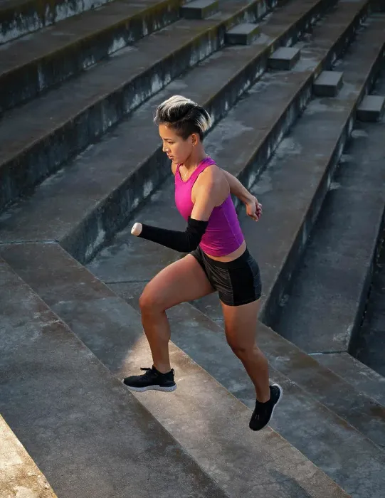 Framed Print : Athletic woman with amputated hand running up steps Framed Print : Athletic woman with amputated hand running up steps