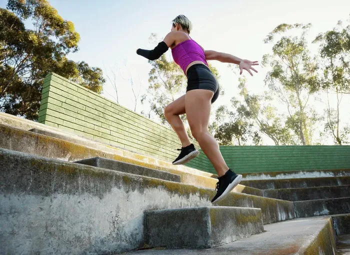 Framed Print : Athletic woman with amputated hand running up steps