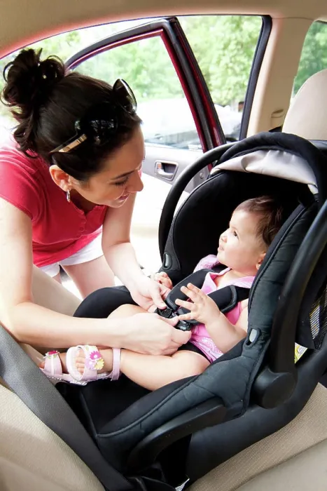 Framed Print : Baby in car seat for safety Happy smiling mother placing baby in car seat and closing belt for safety Framed Print : Baby in car seat for safety Happy smiling mother placing baby in car seat and closing belt for safety