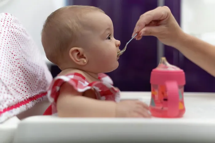 Framed Print : baby eating porridge, sela gives her mother Framed Print : baby eating porridge, sela gives her mother