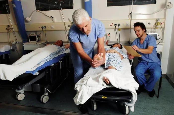 Framed Print : Bearded surgeon checking female patient in hospital bed Framed Print : Bearded surgeon checking female patient in hospital bed