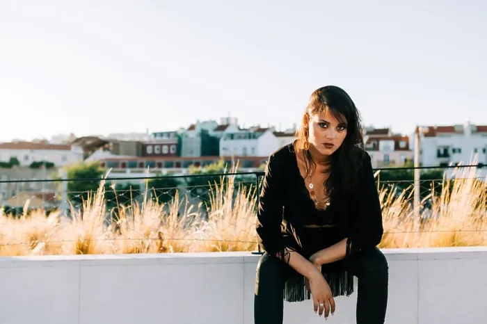 Framed Print : Beautiful stylish woman in black outfit sitting with city landscape in Lisbon on sunny day